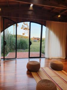 a room with two stools on a wooden floor at Hostería Casa Angirû in Colonia Chapadmalal