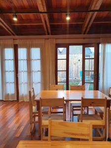 a dining room with a large wooden table and chairs at Hostería Casa Angirû in Colonia Chapadmalal