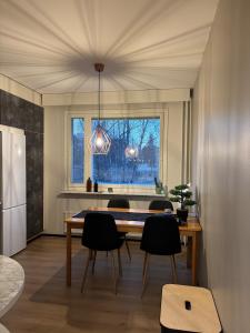 a dining room with a table and chairs and a window at Stylish and cozy apartment in Rovaniemi
