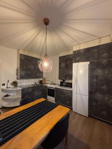 a kitchen with a table and a white refrigerator at Stylish and cozy apartment in Rovaniemi
