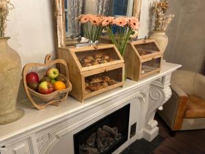 a fireplace with crates of fruits and vegetables on it at B&B Saint-Sauveur Bruges in Bruges
