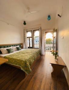 Un dormitorio con una cama grande con una colcha verde. en The Haveli Stays Udaipur, en Udaipur