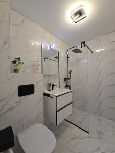 Un baño blanco con inodoro y ducha. en Apartament de Vacanță Straja, en Lupeni