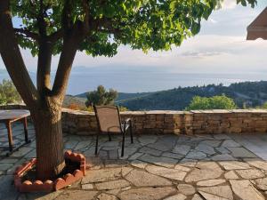 een boom naast een tafel en een stoel bij Holiday house afetes in Afétai