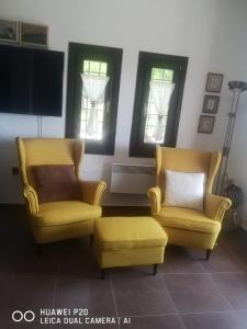 twee gele stoelen en een voetenbank in een woonkamer bij Holiday house afetes in Afétai