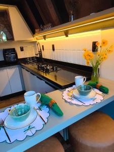 un tavolo con due tazze e piatti sopra in cucina di Chalés Sol e Sal de Capri a São Francisco do Sul
