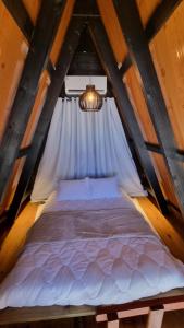 un grande letto in una mansarda con una finestra di Chalés Sol e Sal de Capri a São Francisco do Sul