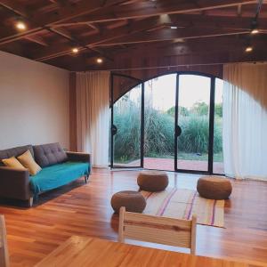 a living room with a couch and a large window at Hostería Casa Angirû in Colonia Chapadmalal