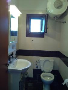 een badkamer met toilet, wastafel en raam bij Holiday house afetes in Afétai