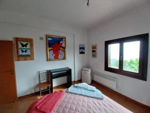 een slaapkamer met een bed, een bureau en een raam bij Holiday house afetes in Afétai