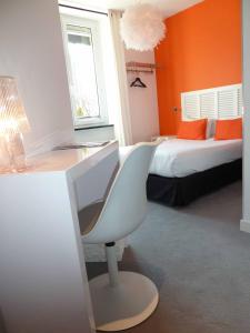 een slaapkamer met een bureau, een bed en een stoel bij Astrid Hotel in Rennes