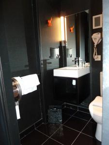 La salle de bains est pourvue d'un lavabo et de toilettes. dans l'établissement Astrid Hotel, à Rennes
