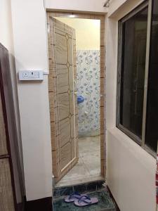 eine Tür zu einer Dusche in einem Raum mit einem Fenster in der Unterkunft 1st floor room in Kalkutta
