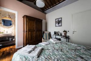 比萨Stanza San Francesco的带床、梳妆台和镜子的卧室