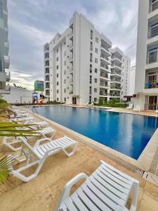 a swimming pool with lounge chairs and buildings at AQUA GARDENS SEAVIEW LUXURY APARTMENTS BAOBAB RD NYALI Msa in Mombasa