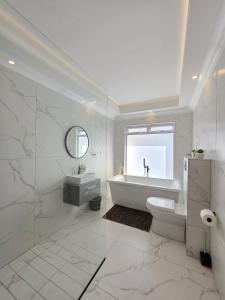 White Cottage Boutique Guesthouse في سواكوبموند: حمام مع حوض استحمام ومرحاض ومغسلة