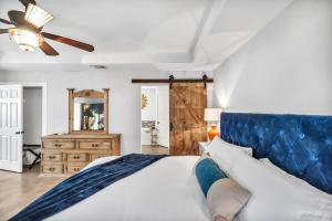 a bedroom with a large bed with a blue headboard at Lakefront Paradise with Firepit in Meadowlakes