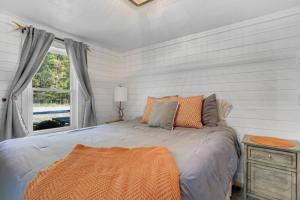 a bedroom with a bed with an orange blanket on it at Family Cottage, Sandy Beach & Paddleboards in Meredith