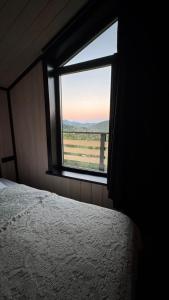 ein Schlafzimmer mit einem Fenster mit Blick auf ein Feld in der Unterkunft Mountain soul hub in Krasnik