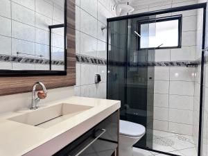 un baño con lavabo y ducha en B484 - Apto 3 quartos perto do mar e com vista., en Bombas 36 fotos más