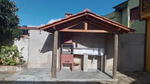 an outdoor kitchen with a roof on a house at Raízes de Afrodite Kitnet in São Thomé das Letras