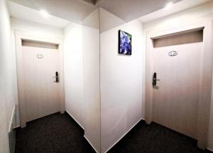 a corridor with two white doors in a room at Alcorso Pension in Banská Bystrica +28 photos
