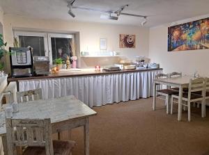 a kitchen with a long counter with tables and chairs at Alcorso Pension in Banská Bystrica