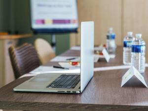 un computer portatile seduto sopra un tavolo di legno di ibis Styles Antibes a Antibes