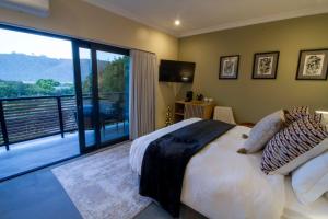 a bedroom with a large bed and a large window at IL Gattopardo in Wilderness