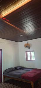 una cama en una habitación con techo de madera en CoCo Camp Stay, en Honāvar