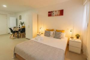 a bedroom with a bed and a table with chairs at Apartamentos Benalua Alicante - Con Parking - Elegir en el momento de la reserva in Alicante