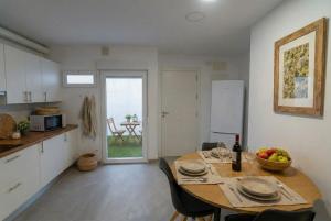 a kitchen and dining room with a table with a bowl of fruit at Apartamentos Benalua Alicante - Con Parking - Elegir en el momento de la reserva in Alicante