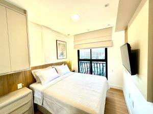 B258 - Apto de luxo com vista mar em Bombinhas في بومباس: غرفة نوم صغيرة مع سرير وتلفزيون