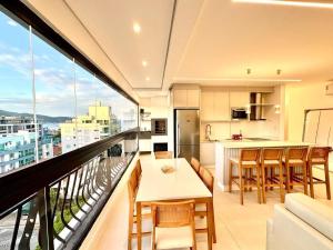 B258 - Apto de luxo com vista mar em Bombinhas في بومباس: شقة مع شرفة مع طاولة وكراسي