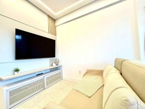 B258 - Apto de luxo com vista mar em Bombinhas في بومباس: غرفة معيشة مع أريكة وتلفزيون بشاشة مسطحة