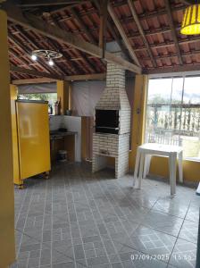 een woonkamer met een stenen open haard en een tafel bij Sítio Cachoeira de Minas in Cachoeira de Minas