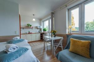 a living room with two beds and a table at Szymonówka W Szklarskiej Porębie in Szklarska Poręba