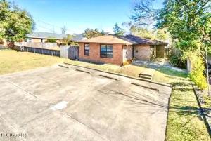 a home with a driveway in front of a house at White Sand Getaway steps from Beach in Gulfport