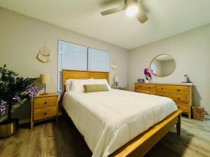 a bedroom with a bed and a dresser and a mirror at NEW Getaway by Gulfport Beach in Gulfport