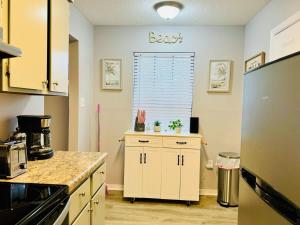 a kitchen with white cabinets and a refrigerator at NEW Getaway by Gulfport Beach in Gulfport +19 photos