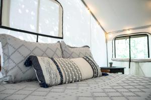 a bedroom with a bed with pillows on it at Blue Heron's Nest - Glamping Tent in the Gorge with AC in Rogers