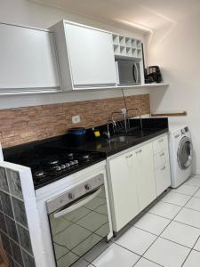 a kitchen with white cabinets and a stove top oven at Residencial Neo 1 in Maceió