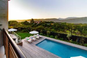 a swimming pool on a balcony with a view of the mountains at IL Gattopardo in Wilderness