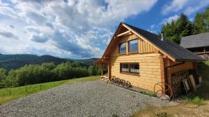 a cabin in the mountains with a gravel driveway at Piernikowa Chata in Zawoja