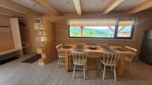 a dining room with a table and chairs in a cabin at Piernikowa Chata in Zawoja