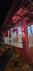 una casa roja con una cerca blanca y ventanas en CoCo Camp Stay, en Honāvar