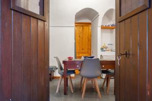 een kamer met een tafel en stoelen en een houten deur bij Appartamento Esperanza Amarillo in Scauri +1 foto