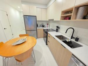 a kitchen with a wooden table and a sink at 2 bedroom heart of Central Surrey in Surrey +6 photos
