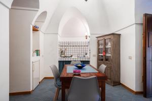 een eetkamer met een houten tafel en stoelen bij Appartamento Esperanza Amarillo in Scauri