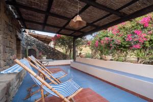 twee stoelen op een veranda met bloemen bij Appartamento Esperanza Amarillo in Scauri